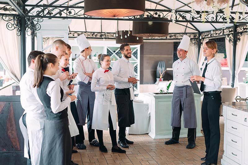 restaurant-manager-his-staff-terrace-interacting-head-chef-restaurant