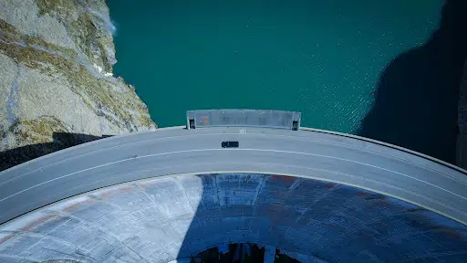Car driving along the top of a dam in Tignes, France, in the EU