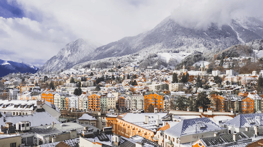 Colourful buildings of Innsbruck below the snow-capped mountains in Austria