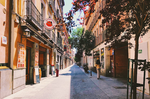 Street between two rows of shops and apartments in Madrid, Spain