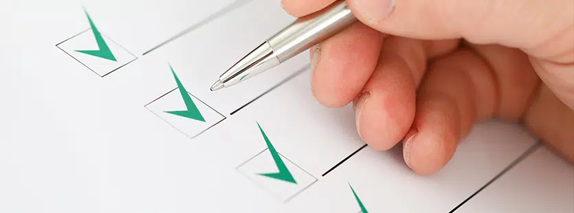 male businessman hand hold silver pen and make green check mark closeup